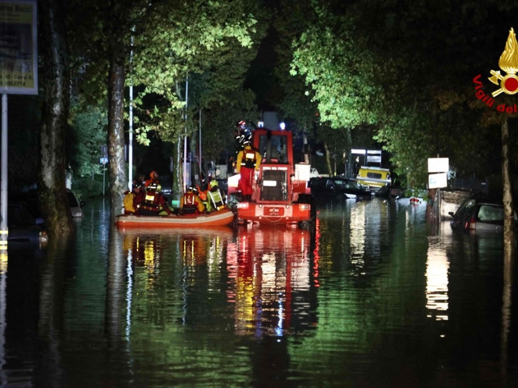 Feuerwehrmnner evakuieren Leute aus berschwemmten Husern in der Nhe von Florenz.