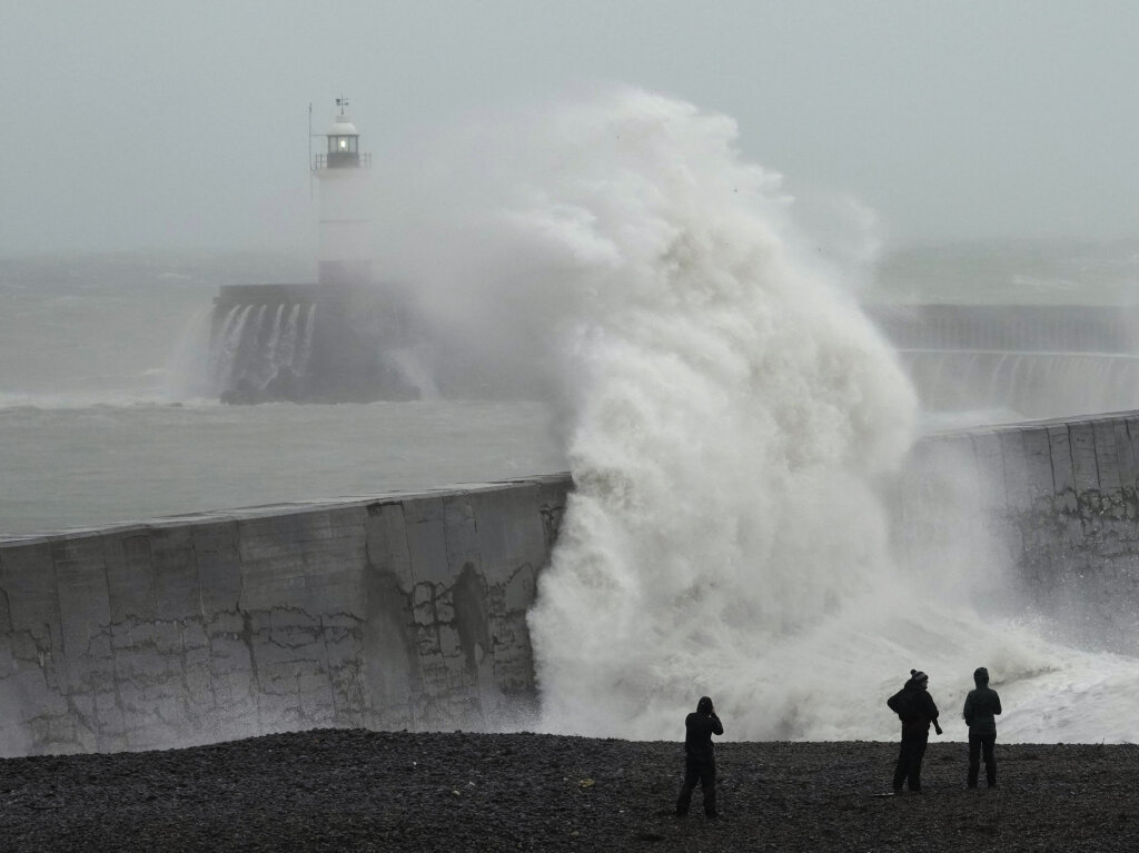 Grobritannien, Newhaven: Wellen brechen ber den Leuchtturm und die Hafenmauer.