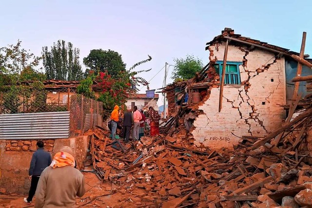 Ein von RSS erhaltenes Bild zeigt Mens...Habseligkeiten in den Trmmern suchen.  | Foto: Sunil Sharma (dpa)