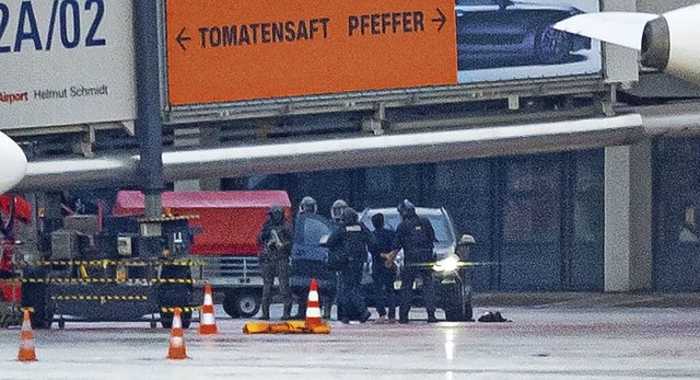 Der mutmaliche Entfhrer wird am Sonn...olizisten auf dem Flughafen abgefhrt.  | Foto: Jonas Walzberg (dpa)