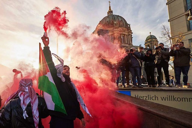 Teilnehmer einer Pro-Palstina-Kundgebung in Berlin znden Pyrotechnik.   | Foto: Jrg Carstensen