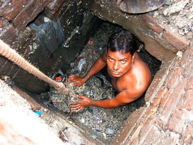 Ein Kanalreiniger arbeitet in einem Auenbezirk von Neu-Delhi.  | Foto: - (dpa)