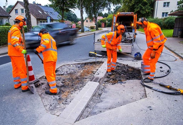 Auszubildende zum Straenwrter breche...eiten die Erneuerung der Fahrbahn vor.  | Foto: Jens Bttner (dpa)