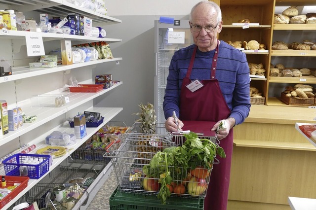 Tafel-Mitarbeiter Werner Melichar notiert die Einkufe einer Kundin.  | Foto: Lara Wehler