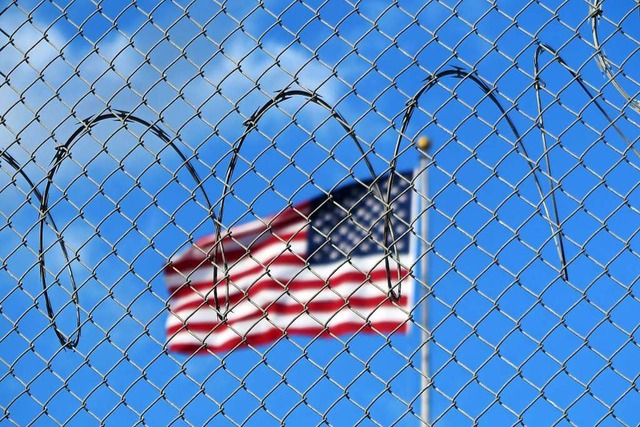 Eine US-Flagge weht hinter Stacheldrah...ahren das umstrittene Gefangenenlager.  | Foto: Magdalena Miriam Trndle (dpa)