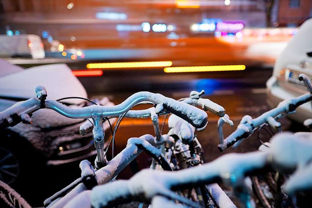 Schnee liegt auf Fahrrädern am Straßen...auerfrost und Glättegefahr einstellen.  | Foto: Sebastian Gollnow (dpa)