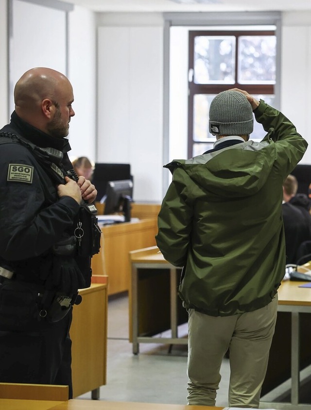 Einer der sechs Angeklagten erscheint vor Prozessbeginn im Gerichtssaal.  | Foto: Jan Woitas (dpa)