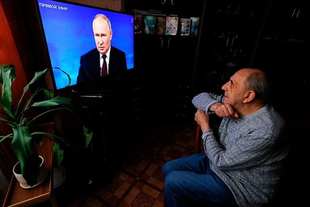 Ein lterer Mann sieht sich die Live-...ressekonferenz von  Wladimir Putin an.  | Foto: OLESYA KURPYAYEVA (AFP)