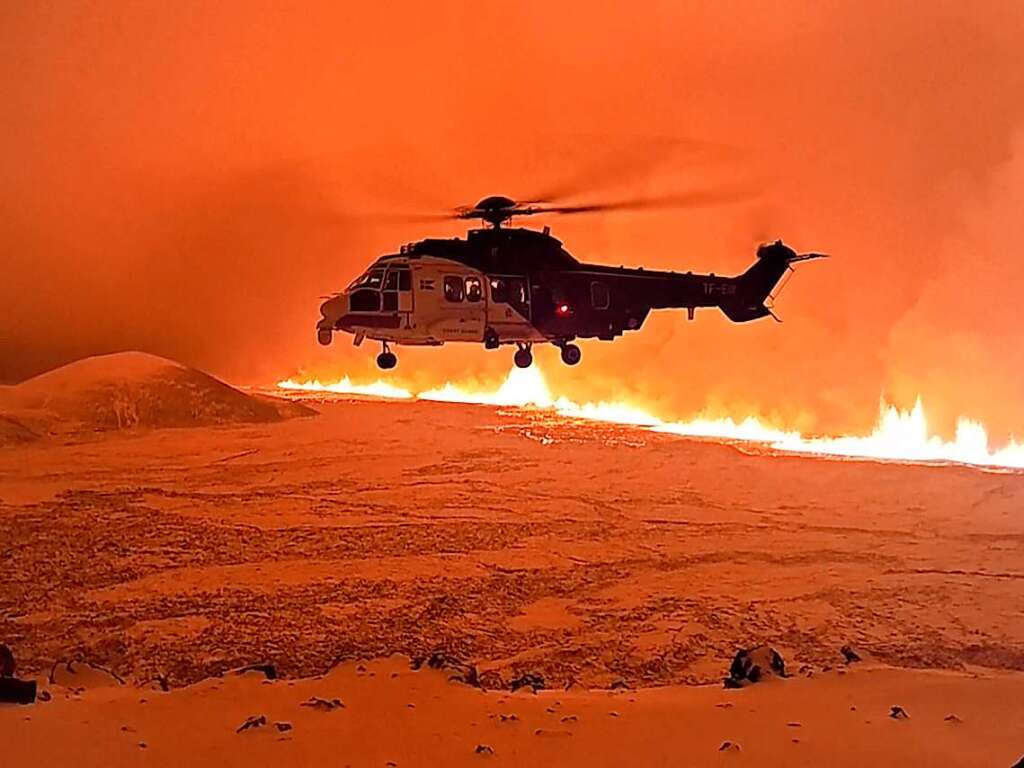 Ein Hubschrauber der islndischen Kstenwache fliegt ber Magma, das auf einem Hgel in der Nhe von Grindavik auf der islndischen Halbinsel Reykjanes fliet.