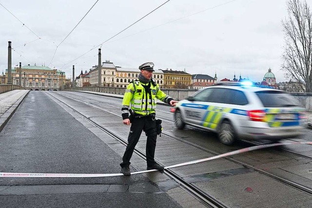 Ein Polizist steht neben einem Polizei...ager Innenstadt sind Schsse gefallen.  | Foto: imnek Vt (dpa)