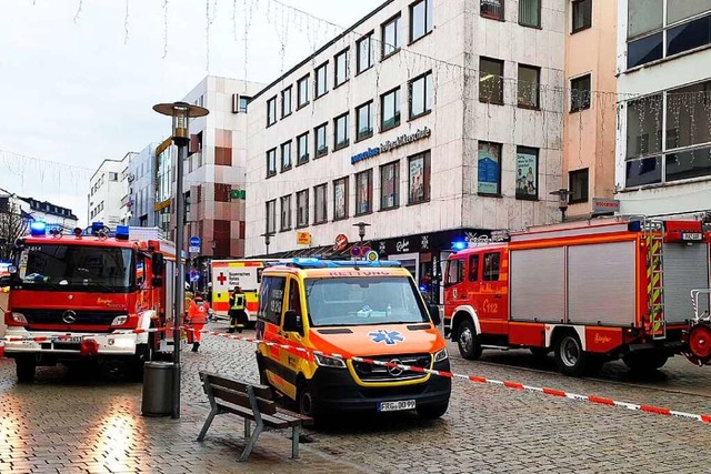 Einsatzkrfte von Feuerwehr und Rettun...tehen in der Innenstadt am Einsatzort.  | Foto: - (dpa)