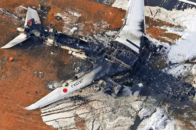 Die Luftaufnahme zeigt das ausgebrannt...pan Airlines auf dem Flughafen Haneda.  | Foto: Uncredited (dpa)