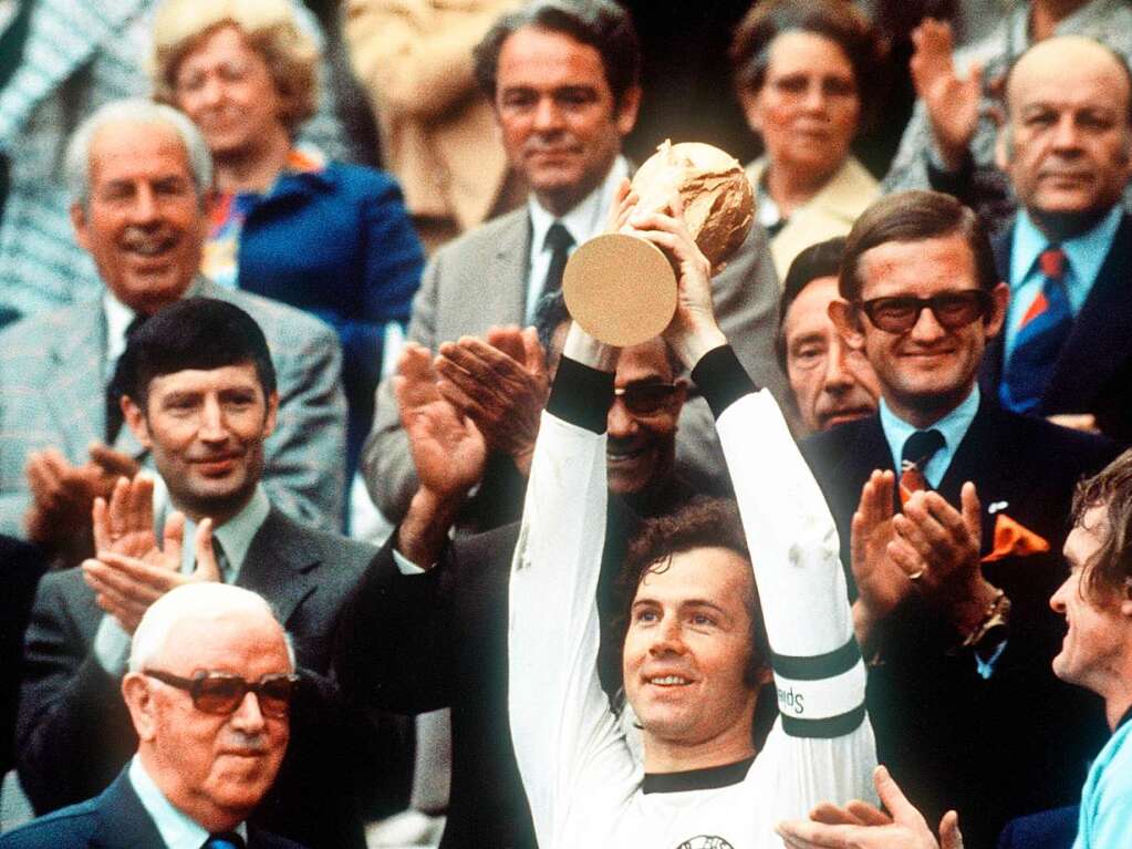 Der WM-Titel als Spieler: Kapitn Franz Beckenbauer (M) hebt an der Seite von Torhter Sepp Maier (r) und dem englischen FIFA-Prsidenten Stanley Rous (l) im Olympiastadion nach dem Endspiel der Fuball-WM den eroberten WM-Pokal hoch.