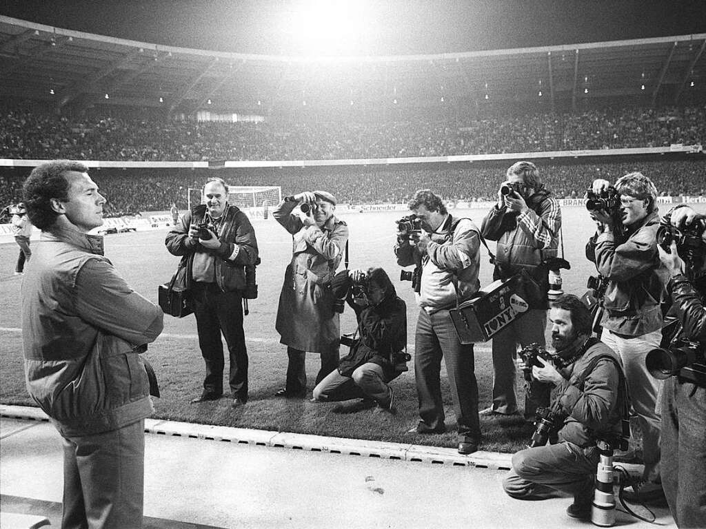 Nach der Laufbahn als Fuballer schlug Beckenbauer den Weg als Trainer ein – und wurde zum DFB-Teamchef. Vor 61.000 Zuschauern im Kln-Mngersdorfer Stadion stand er im Oktober 1984 im Blickpunkt einer Schar von Fotografen.