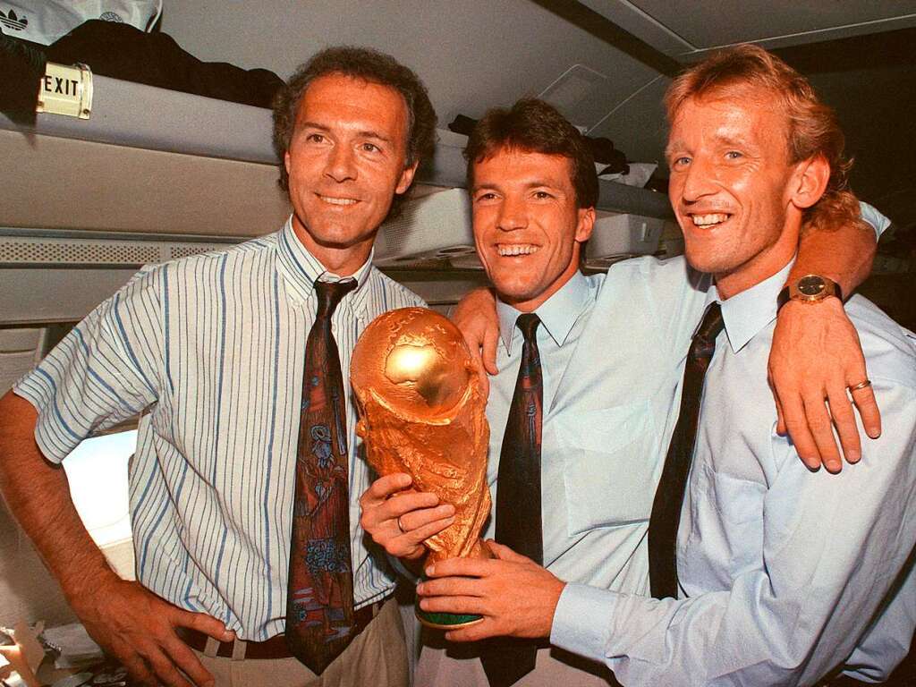 Franz Beckenbauer, Lothar Matthus und Andreas Brehme mit dem WM-Pokal.