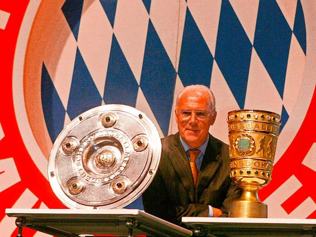 Neben seiner Karriere beim DFB war Beckenbauer stets beim FC Bayern beheimatet. Als Spieler, Trainer, Prsident und Ehrenprsident. Der damalige Prsident des Fuball-Bundesligisten FC Bayern Mnchen, Franz Beckenbauer, steht im Jahr 2006 zwischen Meisterschale und DFB-Pokal unter dem Vereinswappen und wartet auf den Beginn der Jahreshauptversammlung.