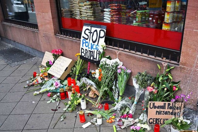 Blumen, Kerzen und Schilder liegen und...eiden beteiligten Beamten vor Gericht.  | Foto: Ren Priebe (dpa)