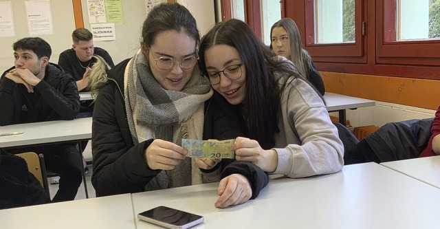 Die beiden Schlerinnen rtseln, ob das Geld echt oder geflscht ist. 