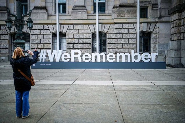 Der Schriftzug #WeRemember steht anl...hstagsgebude mit Deutschen Bundestag.  | Foto: Kay Nietfeld (dpa)