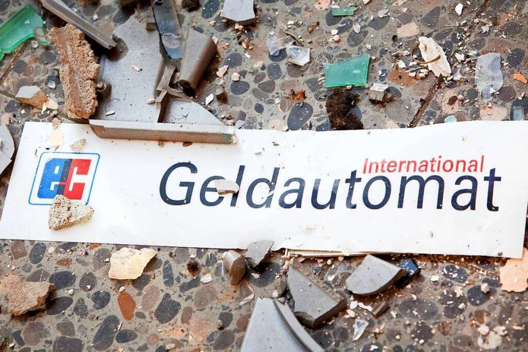 Splitter liegen vor einem gesprengten Geldautomaten auf dem Boden.  | Foto: Patrick Pleul (dpa)