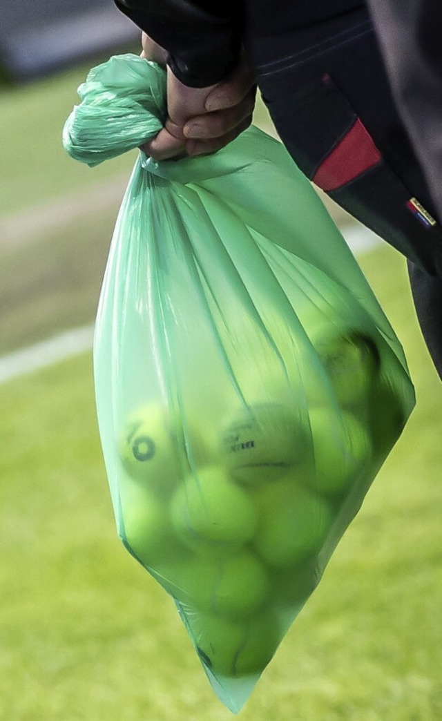 Ein Ordner entfernt beim Spiel Union B...n Sack mit Tennisbllen vom Spielfeld.  | Foto: Andreas Gora (dpa)