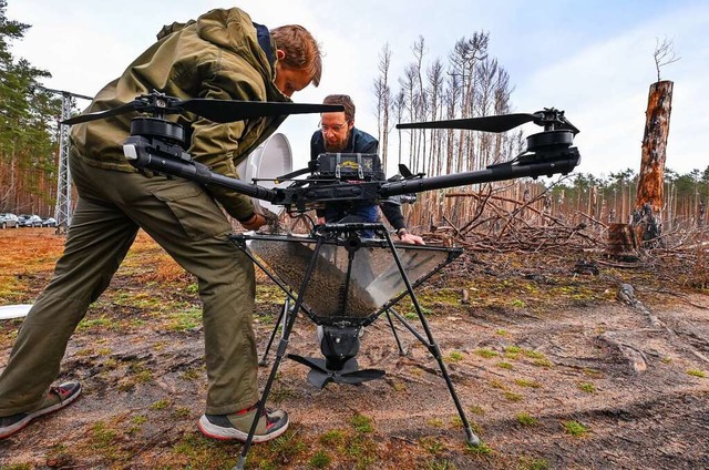 Markus Patas, Drohnenpilot und Ole Sei... Behlter an einer Drohne mit Saatgut.  | Foto: Patrick Pleul (dpa)