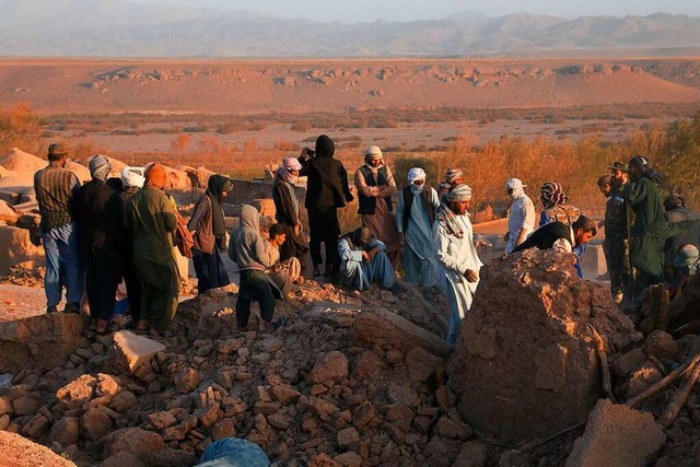 Menschen stehen nach einem Erdbeben in... 2023 in den Trmmern von Wohnhusern.  | Foto: Mashal