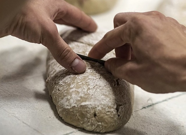 Eine Person backt ein Brot.  | Foto: Fabian Sommer (dpa)