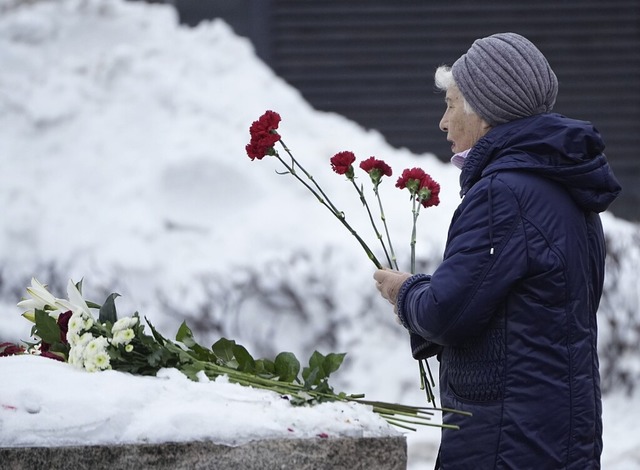 In Moskau legt  eine Frau Blumen in Erinnerung an  Alexej Nawalny nieder.  | Foto: Alexander Zemlianichenko (dpa)