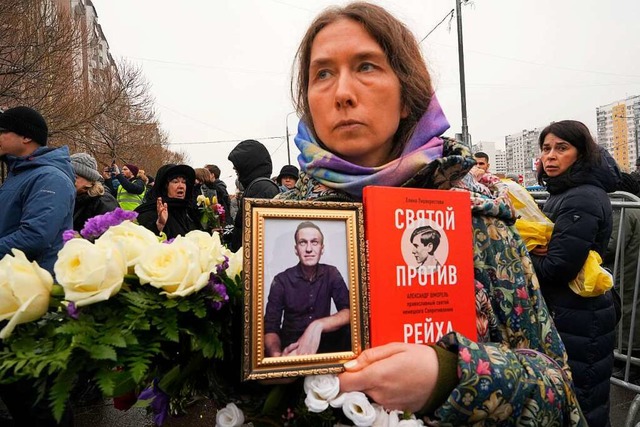 Eine Frau hlt ein Portrt von Alexej ...eisetzung des Kremlgegners versammeln.  | Foto: Uncredited (dpa)