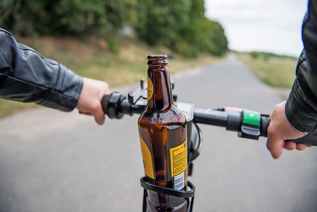 Der Fahrer eines E-Scooters ist mit einem Bier unterwegs. (Symbolbild)  | Foto: Robert Guenther (dpa)