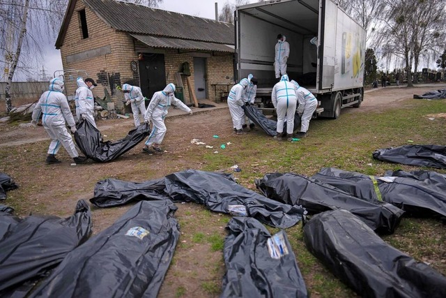 Butscha, April 2022: Freiwillige laden...ischer Zivilisten auf einen Lastwagen.  | Foto: Rodrigo Abd (dpa)