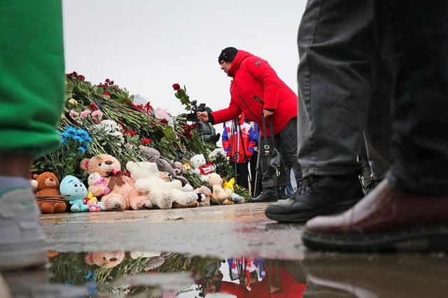 Menschen legen Blumen nieder am  Impro...rtes Denkmal vor der Crocus City Hall.  | Foto: Vitaly Smolnikov (dpa)