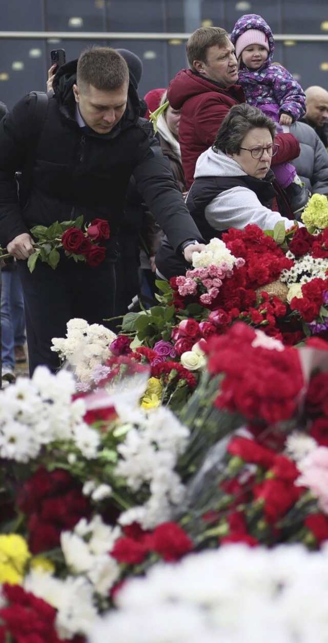 Vor dem Konzertsaal trmt sich ein Berg aus Blumen.  | Foto: Vitaly Smolnikov (dpa)