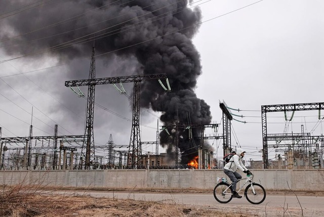 Ukraine, Charkiw: Ein Mann radelt nach...iff an einem Elektrizittswerk vorbei.  | Foto: Yevhen Titov (dpa)