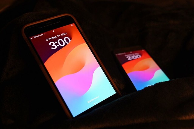 Die Zeitumstellung auf zwei Smartphones fr die Sommerzeit  | Foto: Alicia Windzio (dpa)