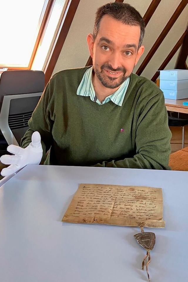 Archivar Daniel Schneider mit dem Pergament von 1270  | Foto: Klaus Riexinger