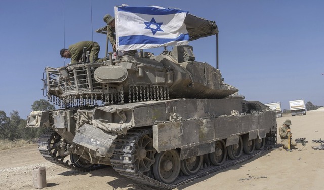 Ein israelischer Soldat befestigt eine...gepanzerten Mannschaftstransportwagen.  | Foto: Ohad Zwigenberg (dpa)