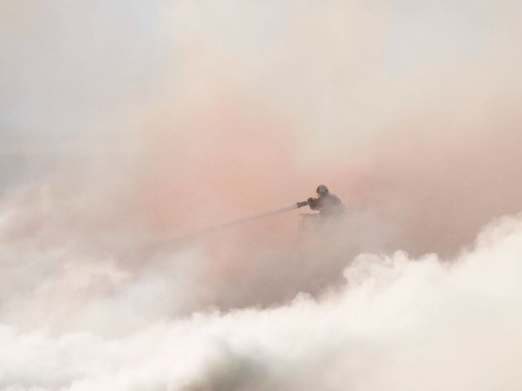 EinFeuerwehrmann bekmpft den Brand im Rauch.