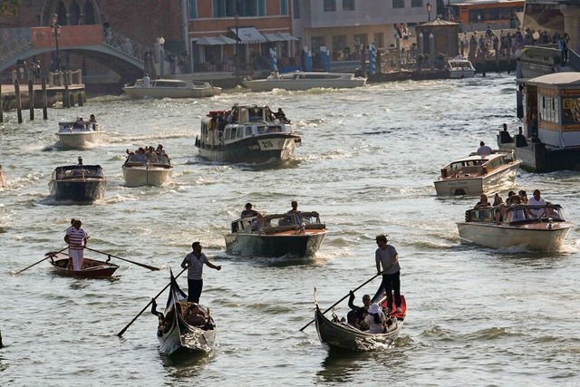 Boote und Gondeln fahren auf einem Kanal in Venedig.  | Foto: Luca Bruno (dpa)