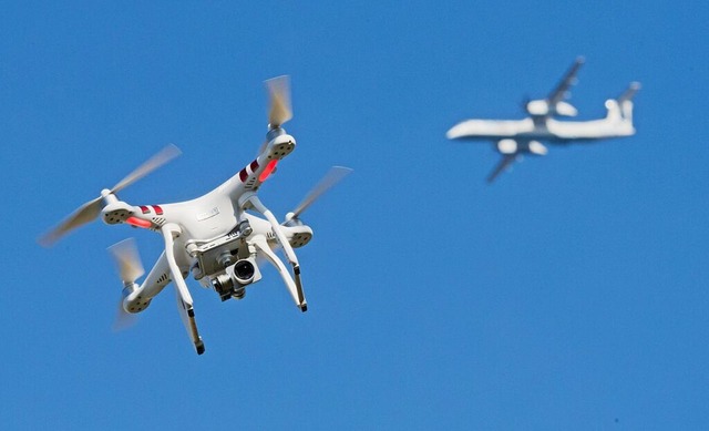 Eine Drohne und ein Flugzeug  | Foto: Julian Stratenschulte (dpa)