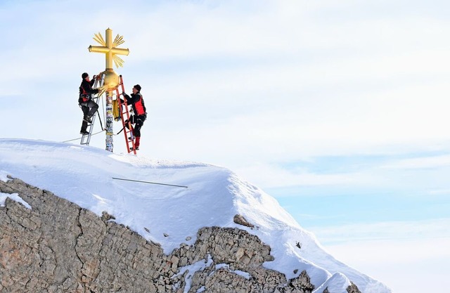 Die im Tal restaurierten Strahlen des ...itern wieder zum Gipfelkreuz gebracht.  | Foto: Angelika Warmuth (dpa)
