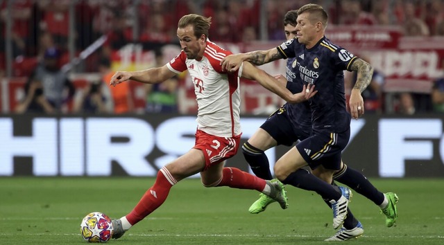 Toni Kroos (rechts) attackiert den Bayern-Spieler Harry Kane.   | Foto: Matthias Balk (dpa)