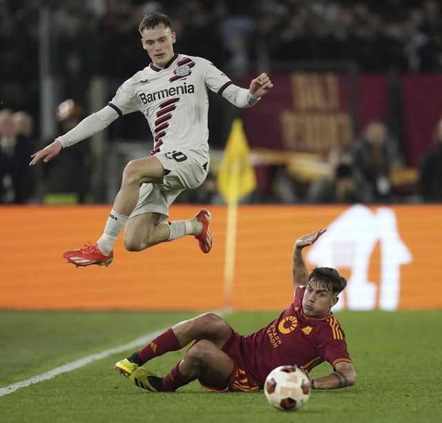 Florian Wirtz springt ber  Paulo Dybala vom AS Rom.  | Foto: Andrew Medichini (dpa)