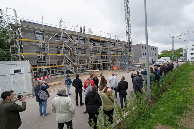 Bauleute, Verwaltungsmitarbeiter und S...rgrund der bereits bezogene erste Bau.  | Foto: Volker Mnch