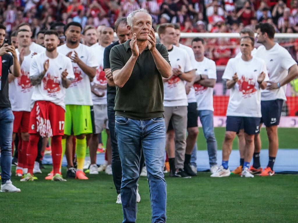 Christia n Streich verabschiedet sich von den Fans des SC Freiburg im Europa-Park-Stadion. Hinter ihm steht seine Mannschaft.