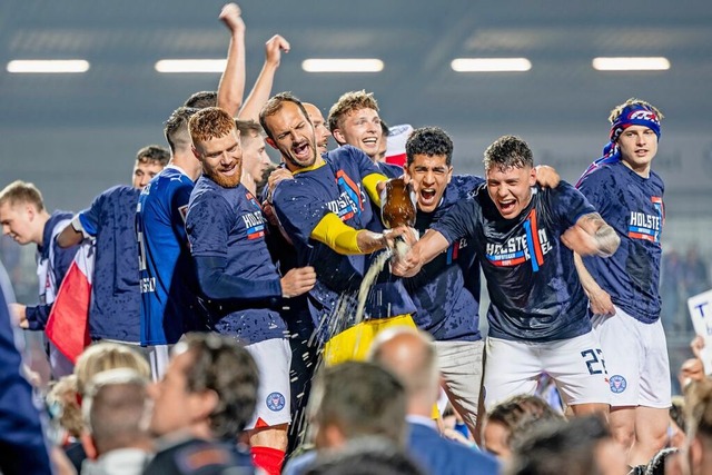 Die Spieler von Kiel feiern mit den Fans gemeinsam den Aufstieg.  | Foto: Axel Heimken (dpa)