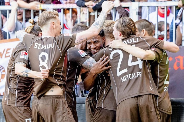St. Paulis Spieler feiern Oladapo Afolayan  fr den Treffer zum 2:0.  | Foto: Axel Heimken (dpa)