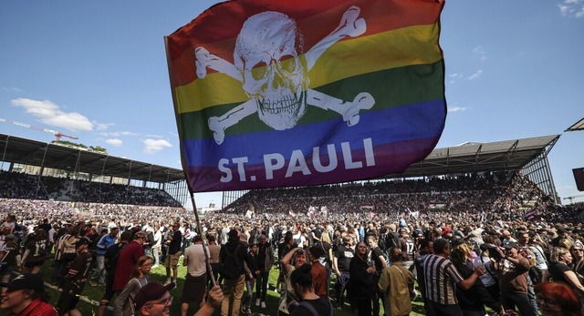 St. Pauli-Fans strmen den Rasen und f... mit Fahne ber den Erstliga-Aufstieg.  | Foto: Christian Charisius (dpa)