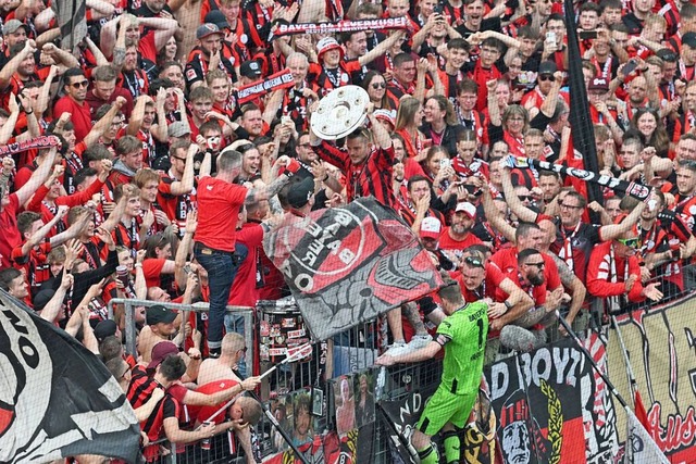 Die Leverkusener Fans jubeln mit der M...radecky  in die Fankurve gebracht hat.  | Foto: David Inderlied (dpa)